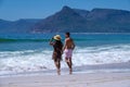 Kommetjie Public Beach Cape Town South Africa, white beach and blue ocean at Kommetjie couple man and woman walking at Royalty Free Stock Photo