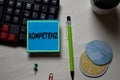 Kompetenz write on a sticky note isolated on office desk. German Language it means Competence
