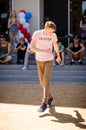 A boy dancing a break dance in the square with spectators