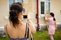 Woman takes picture of her friend getting ready to throw dart at