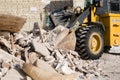 Bulldozer excavator shoveling debris into pile with his ladle