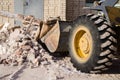 Bulldozer excavator shoveling debris into pile with his ladle