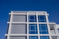 Facade of modern business building with large mirrored windows and balcony against blue sky Royalty Free Stock Photo