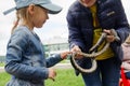 Girl touches a snake overcoming her fear. Raising a child`s courage and curiosity