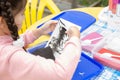 Girl with pigtails draws a picture with colored sand. child creative development concept