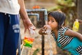 Kon Tum, Vietnam - Mar 29, 2016: A little girl drink water from outdoor tap which water supplied by drilling well in Central Highl