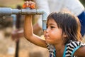 Kon Tum, Vietnam - Mar 29, 2016: A little girl drink water from outdoor tap which water supplied by drilling well in Central Highl