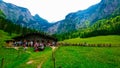 tourists resting around a wooden cottage which served food and drinks with the background of mountains range under a Royalty Free Stock Photo