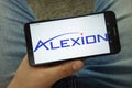 Man holding smartphone with Alexion Pharmaceuticals Inc. company logo Royalty Free Stock Photo