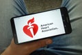 Man holding smartphone with American Heart Association AHA logo Royalty Free Stock Photo