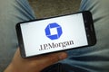 Man holding smartphone with JP Morgan Chase & Co. logo