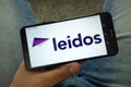 Man holding smartphone with Leidos company logo Royalty Free Stock Photo