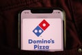 KONSKIE, POLAND - August 17, 2021: Dominos Pizza logo on mobile phone hidden in jeans pocket