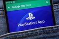 PlayStation app on Google Play Store website displayed on smartphone hidden in jeans pocket