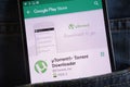 UTorrent app on Google Play Store website displayed on smartphone hidden in jeans pocket