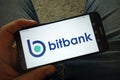 Man holding smartphone with Bitbank cryptocurrency exchange logo