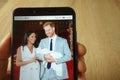 KONSKIE, POLAND - May 18, 2019: hand holding smartphone with photo of Prince Harry and Meghan Markle with baby Royalty Free Stock Photo