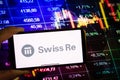 KONSKIE, POLAND - September 10, 2022: Smartphone displaying logo of Swiss Re company on stock exchange chart background