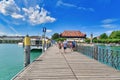 Konstanz, Germany - Long wooden footbridge at Lake Constance harbor with tourists on sunny summer day Royalty Free Stock Photo