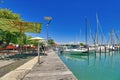 Konstanz, Germany - Outdoor cafes with umbrellas at yacht marina at harbor at Lake Constance on sunny summer day Royalty Free Stock Photo