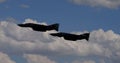 Dramatic black silhouettes of two supersonic fighters flying in close formation