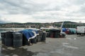 Black plastic buckets and boxes filled with fishing nets ready to load in boats moored in fishing port in Koper, Slovenia.