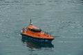 Modern orange pilot boat with blue hull.