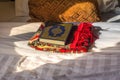 Koran bible and a scarf on the bed with background of pillow under sunlight in the hotel of Saudi Arabia