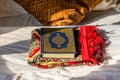 Koran bible and a scarf on the bed with background of pillow under sunlight in the hotel of Saudi Arabia