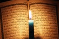 Koran or quran holy book with candle on candlelight