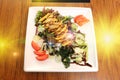 Korea Food in Restaurant on wooden table, Marinated Chicken Mango Salad with vegetable on white square plate Royalty Free Stock Photo