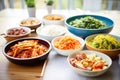 korean banchan side dishes assortment with kimchi as centerpiece