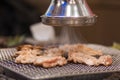 A closeup of a Korean BBQ exhaust fan sucking smoke from the BBQ stove.