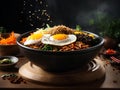 Korean bibimbap, floating, popular rice bowl dish made with cooked rice, vegetables, meat, fried egg