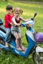 Korean boy and caucasian girl on a blue scooter on Royalty Free Stock Photo