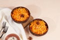 Korean carrot salad in coconut bowls. Fresh organic grated carrot with pepper, sesame and garlic.