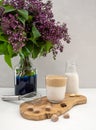 The Korean coffee drink Dalgona made from almond milk with lilac flower on the white background Royalty Free Stock Photo