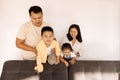 A Korean couple and their cute little kids on the sofa in the living room Royalty Free Stock Photo