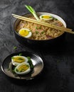 Korean food. Udon noodles with bacon, egg and green onions on dark background Royalty Free Stock Photo
