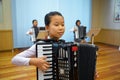 Pyongyang, North Korea-October 12,2017:Korean girl plays the accordion at the Palace of Pioneers and Schoolchildren Royalty Free Stock Photo