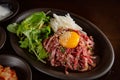 Korean Grilled BBQ combo sets with egg yolk beef tartare with pickle salad on the dark plate