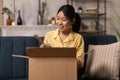 Korean Lady Unpacking Parcel With Cosmetics Products And Tools Indoors Royalty Free Stock Photo