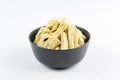 Korean marinated asparagus in a black bowl on a white background, isolate, close-up side view