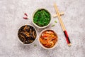 Korean pickled food set and chopsticks on gray background
