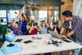 Korean scientist with the group of young pupils with laptop and VR headsets during a computer science class. Excited Royalty Free Stock Photo