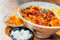 Korean stir fried chicken rice in white bowl on wooden table