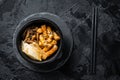 Korean street food Tteokbokki, Topokki fried rice cake stick in spicy sauce. Black background. Top view Royalty Free Stock Photo