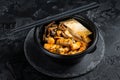 Korean street food Tteokbokki, Topokki fried rice cake stick in spicy sauce. Black background. Top view Royalty Free Stock Photo