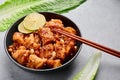 Korean Sweet Fried Chicken Dakgangjeong in black bowl at grey concrete table top. Korean Food Royalty Free Stock Photo