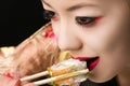 Korean teenager girl with bright makeup eating sushi closeup Royalty Free Stock Photo